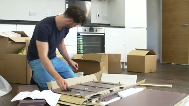 Man Putting Together Self Assembly Furniture In New Home