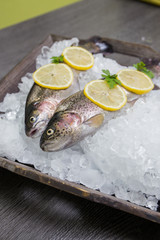 Frische Forelle mit Limone auf einem Holztablett