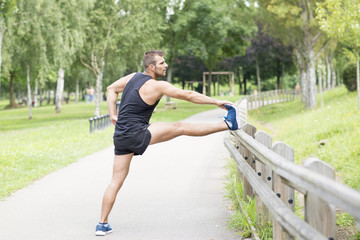 Athletic man doing stretches before exercising, outdoor.