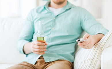 man with beer and remote control at home