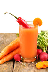 Fresh carrot juice with vegetables on wooden table