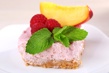 Cake with fruits and berries on plate on wooden background