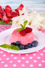 Round shaped cake with berries on plate on polka dot table