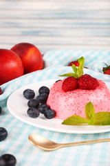 Round shaped cake with berries on plate on table cloth