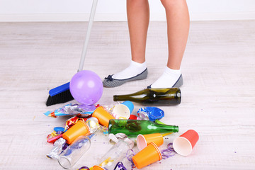 Woman cleaning grey wooden floor from mess