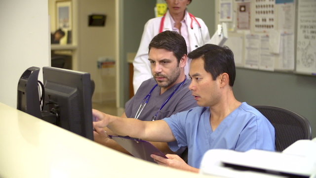 Medical Staff Working At Busy Nurses Station