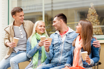 group of smiling friends with take away coffee