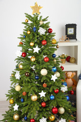 Decorated Christmas tree on home interior background