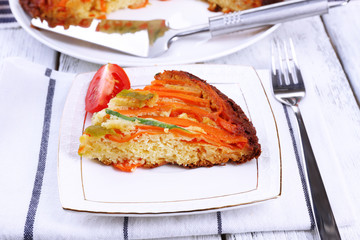 Piece of casserole with vegetables on plate on table close-up