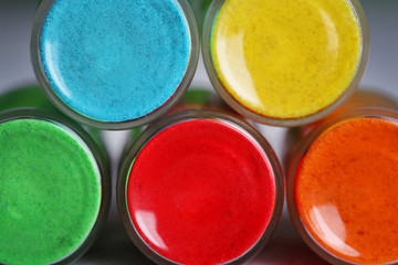 Bottles with colorful dry pigments on wooden background