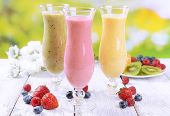 Delicious berry cocktails on table on bright background