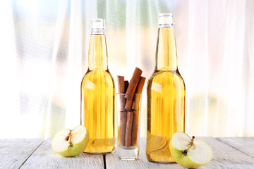 still life with apple cider and fresh apples on wooden table