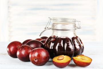 Tasty plum jam in jar and plums