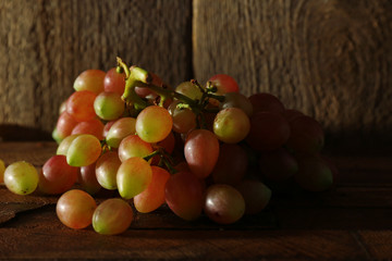 Pink grape on wooden table on wooden background
