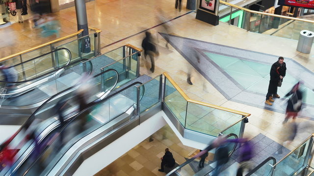Time Lapse Sequence Of Shoppers On Escalators In Mall