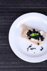 Slices of bread with butter and black caviar