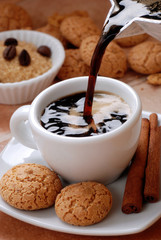 versare il caffè caldo nella tazzina bianca
