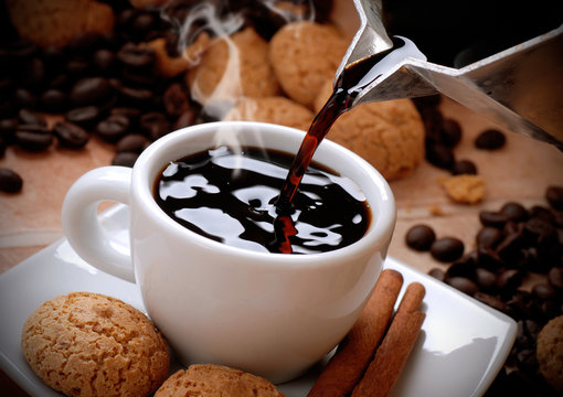 Fototapeta versare il caffè caldo nella tazzina bianca