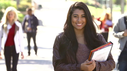 Female Student Walking Outdoors On University Campus