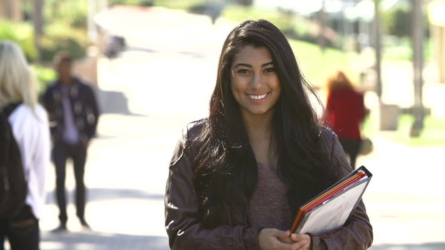 Female Student Walking Outdoors On University Campus