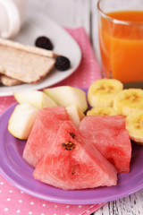 Slices of fruits with crispbreads and glass of juice