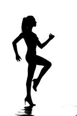 Fototapeta na wymiar silhouette of a young pretty woman walking on white