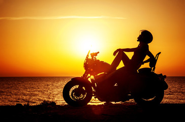 Obraz na płótnie Canvas Woman biker enjoying sunset