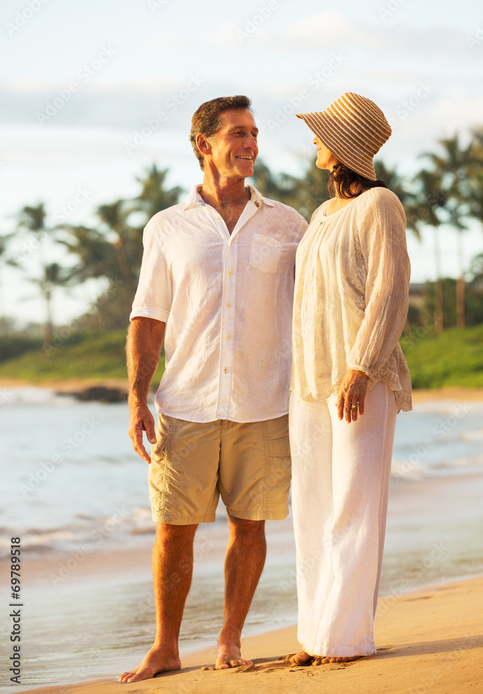 Wall mural Mature Couple Enjoying Sunset on the Beach