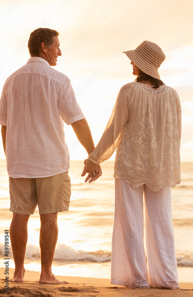 Wall mural mature couple holding hands enjoying at sunset