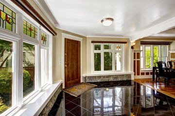 Foyer with black shiny tile floor and stone trim under the windo