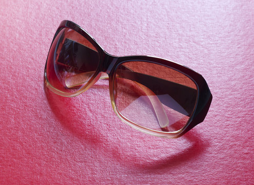 Pretty and shiny sunglasses on a red background