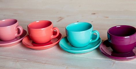 Colorful coffee cups on wooden table