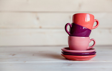 Colorful coffee cups over obsolete grunge wooden background