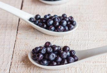 Blueberries in ceramic spoons, vertically