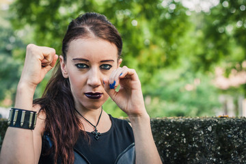 Pretty goth girl posing in a city park