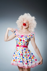 Clown with white wig against grey background