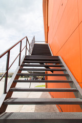 Metal fire escape or emergency exit on Orange Wall of Buliding