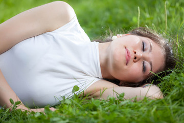 Naklejka na ściany i meble young woman sleeping on grass
