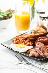 Full English breakfast with bacon, sausage, egg, baked beans and