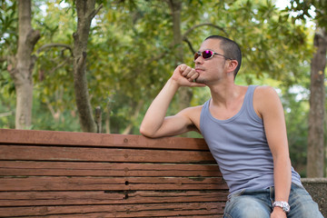 ベンチで頬杖をつく男性