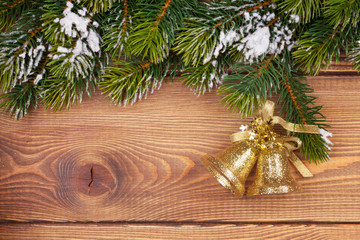 Christmas fir tree with snow and holiday decor on rustic wooden