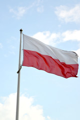 Naklejka na ściany i meble National flag of Poland flutters against the blue sky