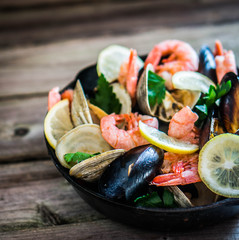 Mix of mussels,clams and shrimps on wooden background