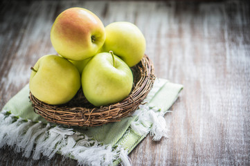 Naklejka na ściany i meble Apples in a basket on rustic background