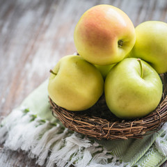 Apples in a basket on rustic background
