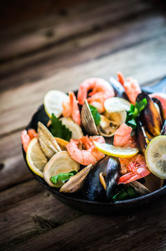Mix of mussels,clams and shrimps on wooden background