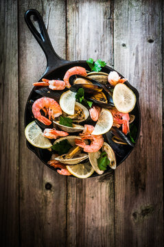 Mix of mussels,clams and shrimps on wooden background