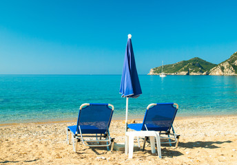 Fototapeta na wymiar Sunbeds and umbrellas on the beach. Corfu Island - Greece