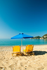 Sunbeds and umbrella on the beach. Corfu Island - Greece