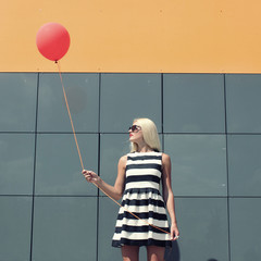 young happy trendy girl  with a red balloon.